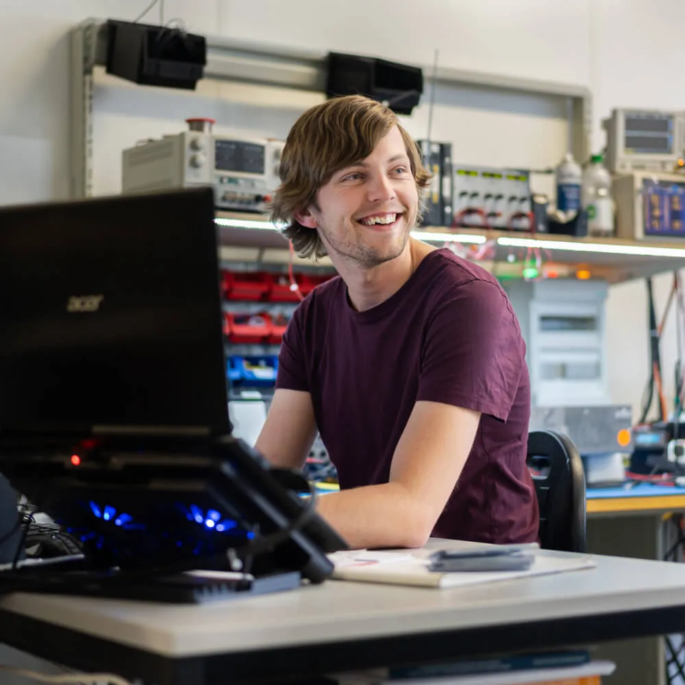 Employee of Heliox at his desk smiling